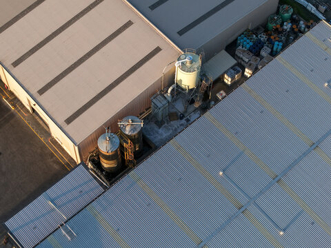 Kilsyth, VIC, Australia - 22 September 2026: Aerial view of industrial factory buildings featuring metal rooftops, large storage silos, and outdoor storage areas.