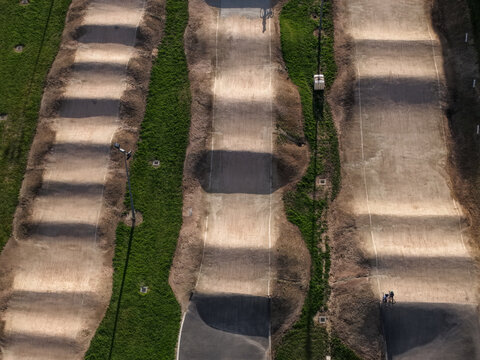 Melbourne, Australia - 22 September 2026: Aerial view of a dirt bmx track with series of mounds and jumps surrounded by green grass.