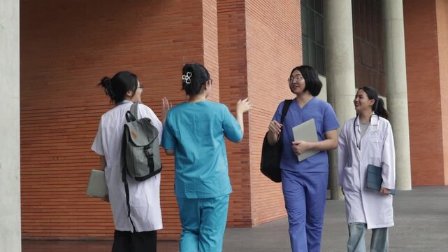 Group medical students greet each  warmly university campus exchanging friendly high fives smiles before heading class in the building classmates medical program get know one friendly atmosphere.
