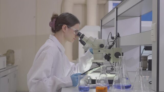 Science, microscope and study with of a woman in a laboratory for research and innovation. Medical, pharmaceutical sample and a young scientist in a lab for development, discovery or breakthrough