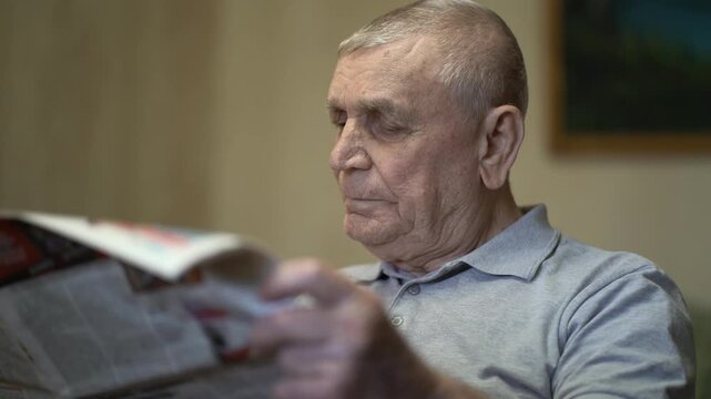 Eighty-year-old senior man reading the morning newspaper at home in a calm domestic setting.
