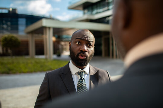 Businessman speaking to colleague outside office building