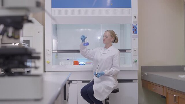 Two lab technicians work together in a modern laboratory with microscopes and samples during a research session