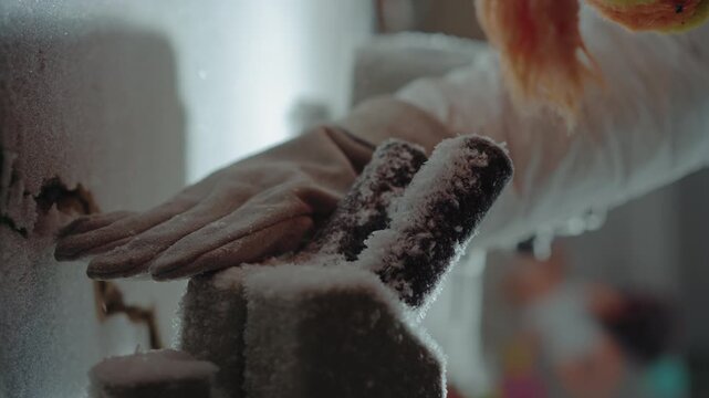 Gloved hand on frozen valve in laboratory control bay, frost and powder covering pipes and gauge while technician reaches under orange hair, closeup of icy machinery, sample retrieval and emergency