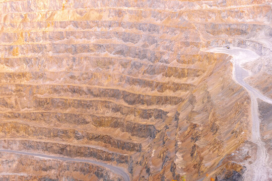 Geamana, Romania - 21 September 2026: Aerial view of the open-pit mine at Geamana, showing terraced rock walls, winding access roads, and the vast scale of the industrial excavation site.