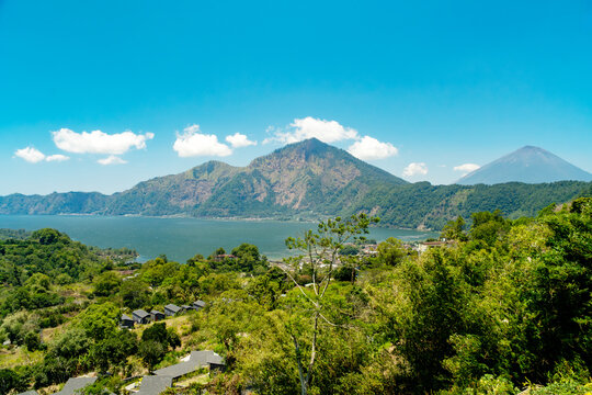 Scenic landscape view of Mount Batur and Lake Batur with Mount Agung in background under blue sky, Kintamani, Bali, Indonesia