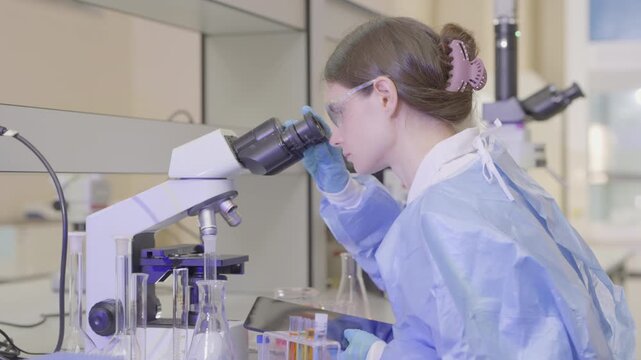 Science, microscope and study with of a woman in a laboratory for research and innovation. Medical, pharmaceutical sample and a young scientist in a lab for development, discovery or breakthrough