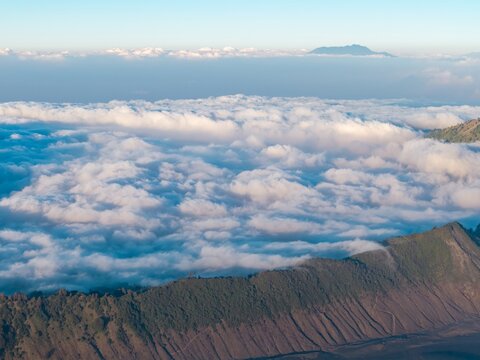Aerial view of Mount Bromo with its volcanic crater rim rising above a vast sea of clouds in the early morning light in Tosari, East Java, Indonesia.