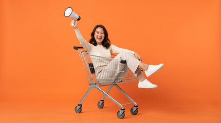 Fototapeta premium Excited Woman Celebrating in Shopping Cart with Megaphone