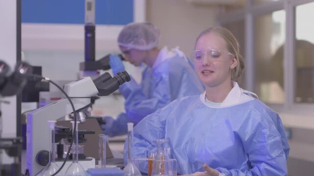 Female scientists analyzing samples with a microscope in a laboratory