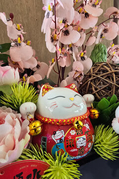 Japanese Maneki Neko Fortune Cat Figurine Arranged with Floral Decoration.