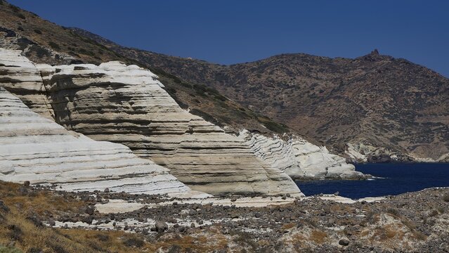 White and brownish strata border the coast with hilly landscape, white volcanic strata, bizarre white rocks in the sea, Little Sarakiniko, Kioni Beach, Kioni, Kimolos Island, Cyclades, Greek Islands, Greece