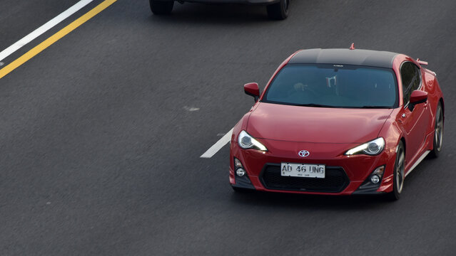 A red Toyota 86 sports car driven on the toll road