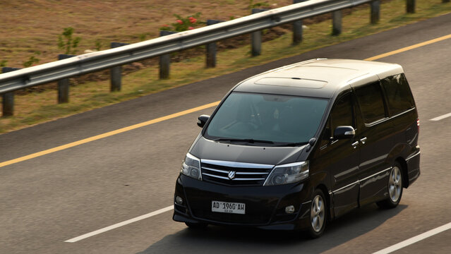 A black Toyota Alphard driven on the toll road