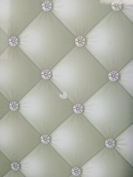 Upholstered leather wall panel texture background. Features diamond tufted design with decorative buttons. Luxury interior decoration material for modern home and office space.