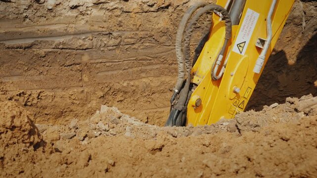 Excavator breaking concrete slab with hydraulic hammer, close-up shot of jackhammer digging trench in slow motion, construction machinery hard at work in dynamic footage.
