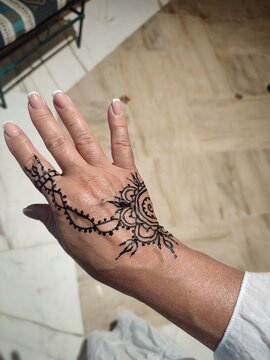 hand with beautiful henna tattoo under artificial light