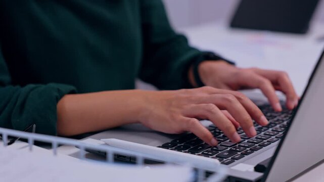 Laptop typing hand on keyboard, technology computer work in office business communication, focused professional remote productivity activity at desk with paper, digital device, modern workspace scene