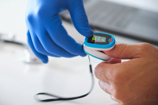 Medical professional monitoring a person's blood oxygen level and pulse rate