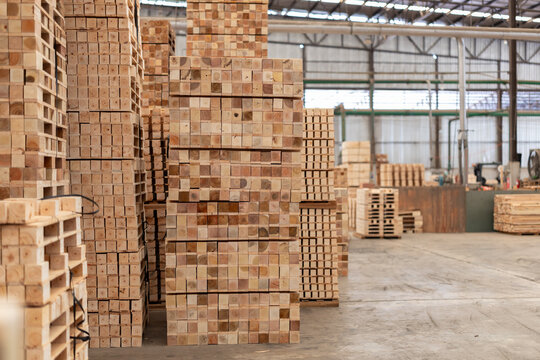 Stacks of wooden boards and wooden pallets in the warehouse