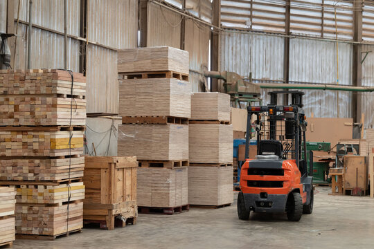 Stacks of wooden boards and wooden pallets in the warehouse
