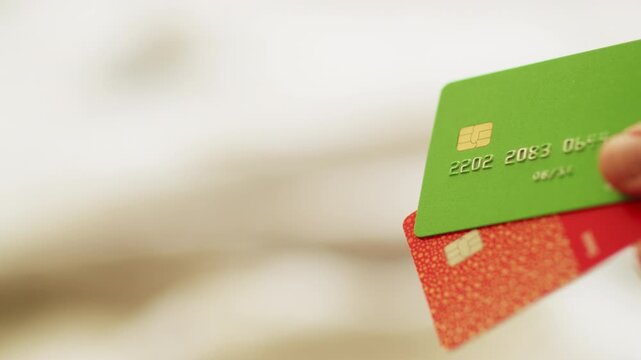 Close up shot of a person holding credit cards. Bank cards with a microchip. Concept of banking, finance, and secure electronic payments. Close up of modern credit cards with a security chip.