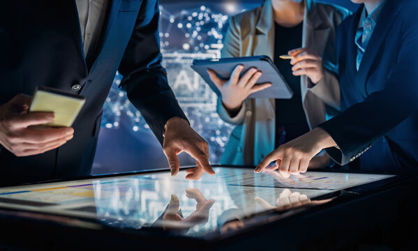 Business Team Collaborating on Interactive Touchscreen Table in Futuristic Office