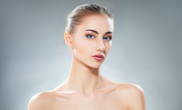 Elegant Young Woman with Perfect Skin and Blue Eyes on Studio Background