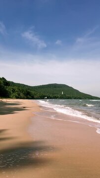 Pristine Golden Sand Beach With Gentle Waves Rolling In Under a Bright Blue Sky in Phu Quoc During Daytime