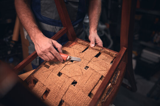 Man working in a workshop for furniture repairing and restoration.