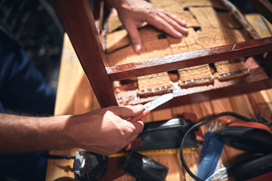 Man working in a workshop for furniture repairing and restoration.