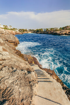 Stone stairway above waves in Cala d'Or, Mallorca, Spain.