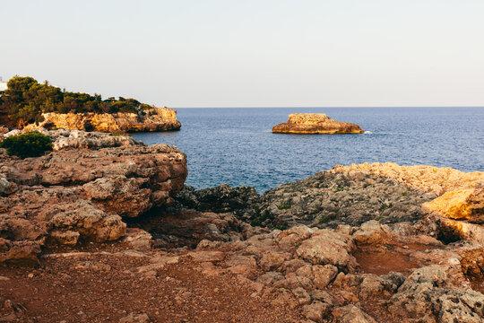 Rocky coast with offshore islet in Cala d'Or, Mallorca, Spain.