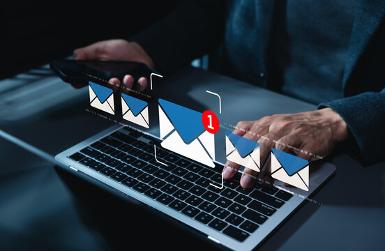 New email notification interaction concept. Person typing on laptop and using smartphone with digital interface showing new email notification symbol, concept for online communication. Email marketing