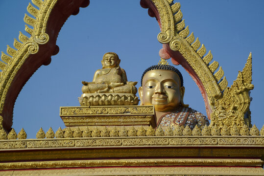 A large brilliantly gold-colored statue of Phra Maha Kaccayana Thera holding a holy water vessel representing the 76 provinces standing 20 meters tall at Wat Lang San Prasit.