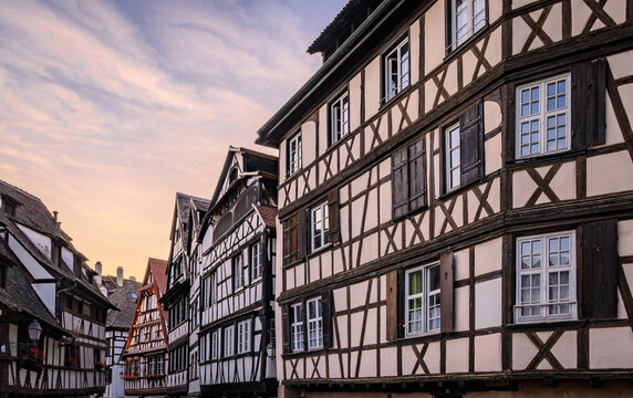 Ornate traditional half timbered houses with blooming flowers along the canals in the Petite France district of Strasbourg, Alsace, France at sunset