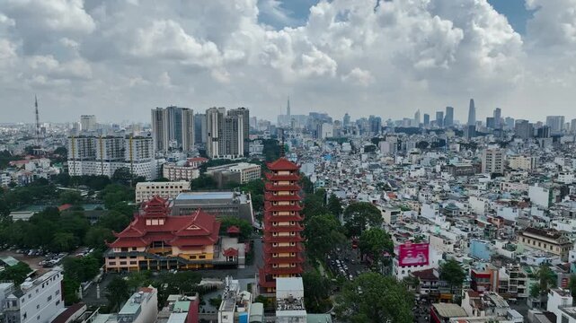 Wide aerial panorama of Vietnam Quoc Tu and its pagoda tower set within the dense cityscape of Ho Chi Minh City, Vietnam