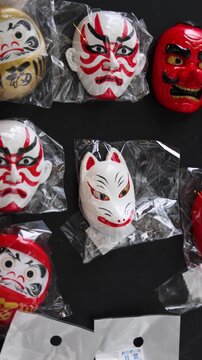 Japanese tourist souvenirs and gifts with symbols of Japan, daruma figure, kitsune fox, tengu mask, mount Fuji, fridge magnets, maneki-neko figurine, key ring keychain, local gift shop in Tokyo, Japan