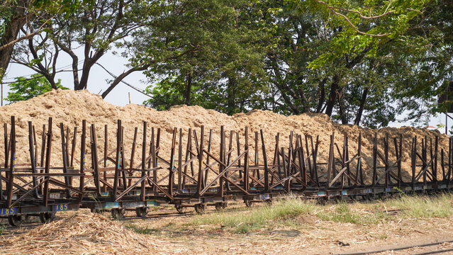 Empty traditional rusty metal sugarcane rail cars parked on narrow tracks at historical Rendeng Sugar Mill in Kudus, Central Java, Indonesia, used for transporting sugar cane during harvest.