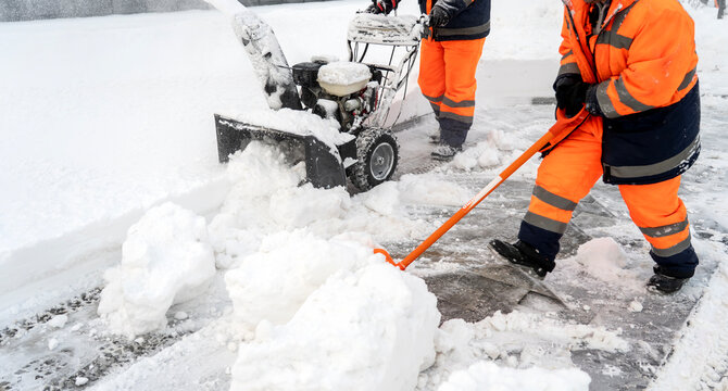 Snow removal workers clear icy streets
