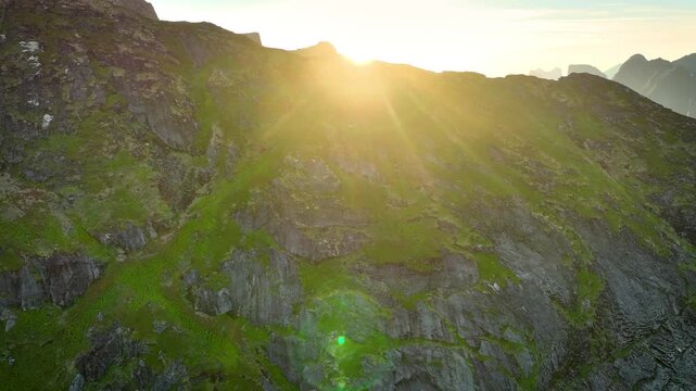Aerial shot of the ocean meeting the mountains along the beautiful coast of Northern Norway near the town of Reine