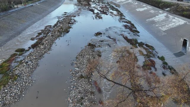 Aerial shot of flood damage and trash in the Los Angeles River after heavy rains.