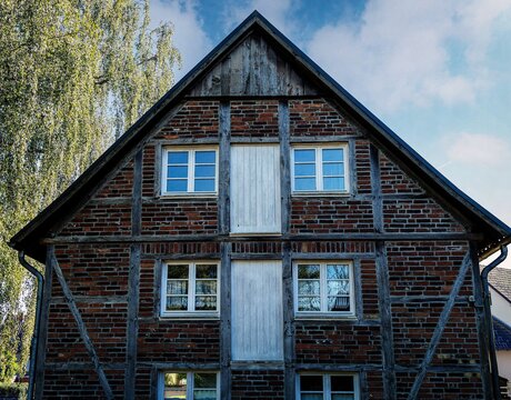 Photograph of a half-timbered house with closed entrance doors on the upper floors.