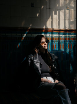 Woman Sitting in Shadow With Sunlight in Urban Space