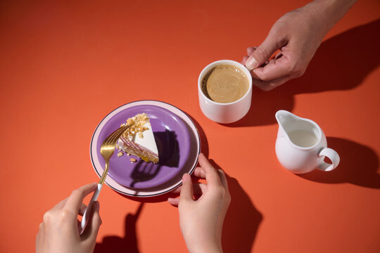 Slice of cake with coffee and cream on a vibrant orange background