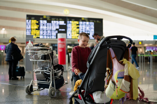 Child smiling playing with baby in airport terminal