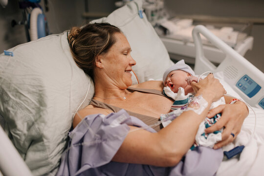A newborn baby rests on her mother's chest after being born.
