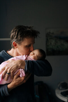A father holds his newborn daughter in the hospital.