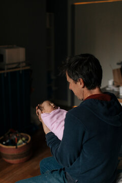 A father holds his newborn daughter in the hospital.