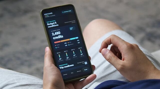 Traveler reviews trip budget, weather outlook and readiness on a smartphone, highlighting digital travel planning, expense control and smarter preparation before departure.